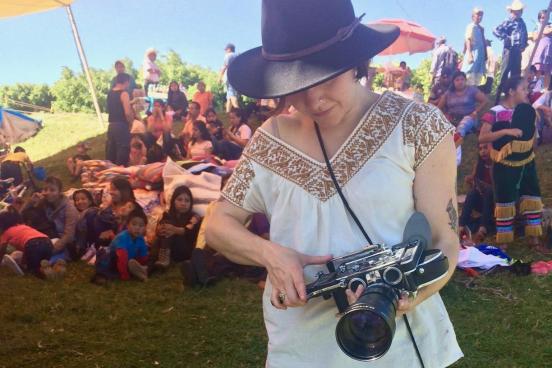 Assistant Professor Talena Sanders with camera in the field.