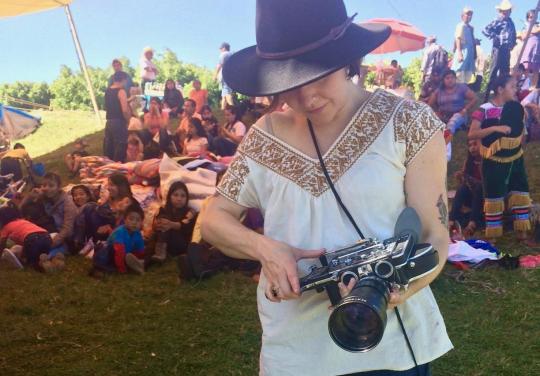 Assistant Professor Talena Sanders with camera in the field.